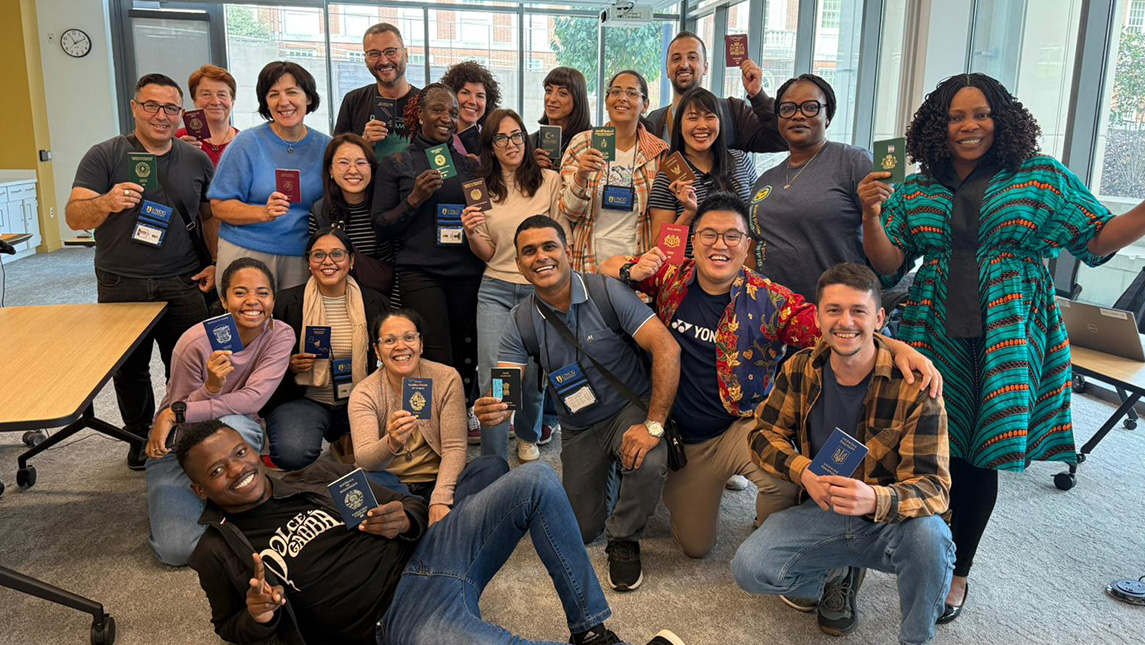 A group of people hold up their passports.