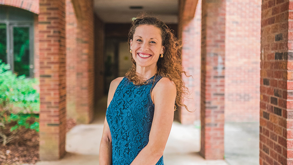 UNCG student Hope Niedrich standing in a walkway.