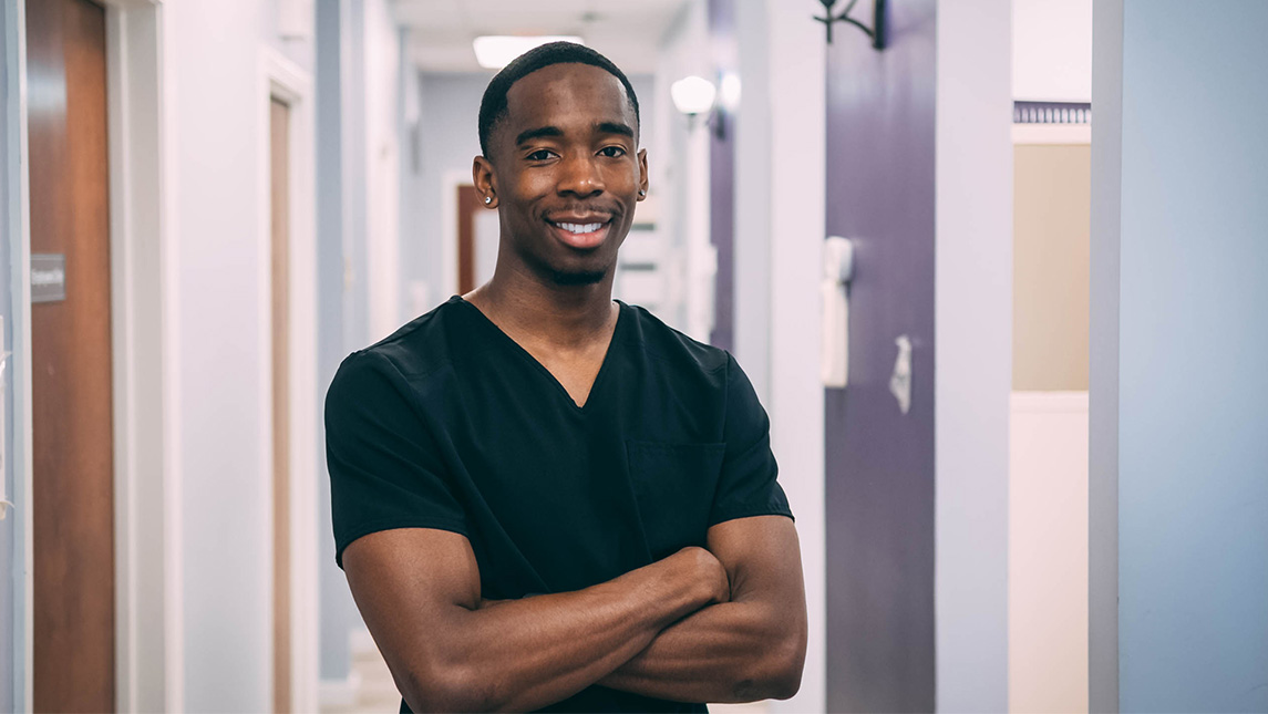 Malachi Ward wearing medical scrubs.