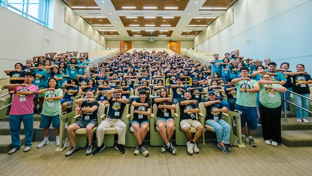Group of students in CHANCE t-shirts in an auditorium style classroom.