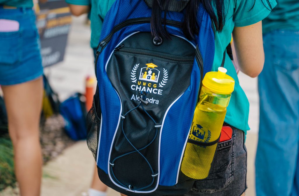 Close-up of a backpack and water bottle with CHANCE embroidered on it.