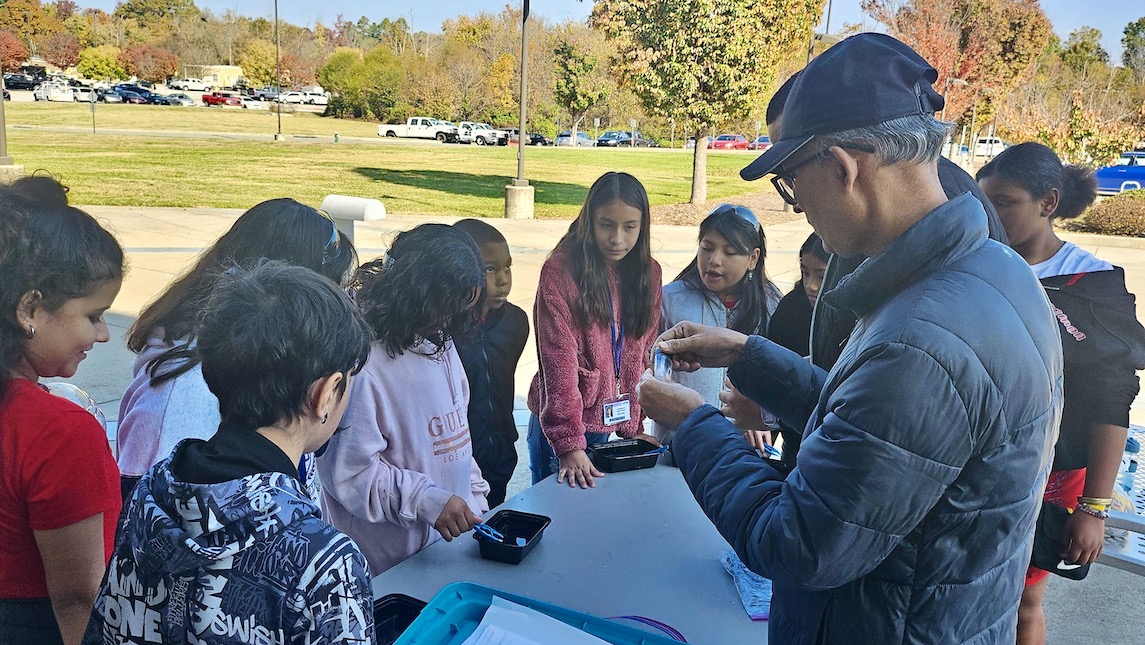 A table set up outside UNCG with children participating in a JSNN community outreach program activity.
