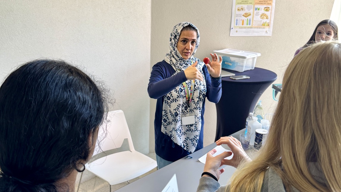 A UNCG JSNN professor explaining an experiment to participates of the UNCG JSNN community outreach program.