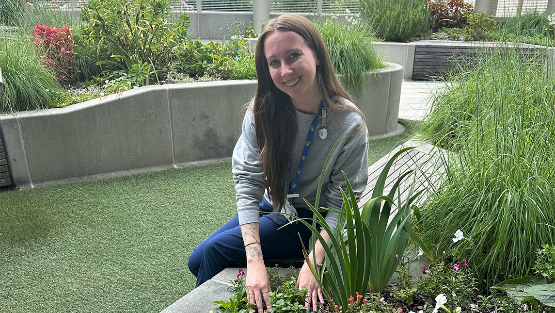 Belle Downing sits in an indoor garden.
