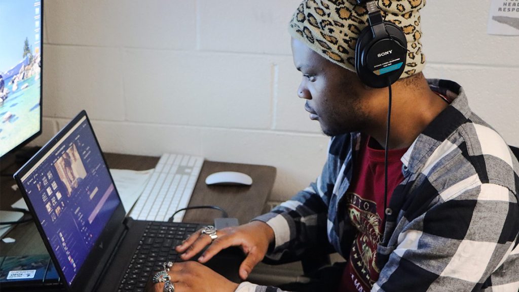 Cole Smith wears headphones while sitting at a laptop.