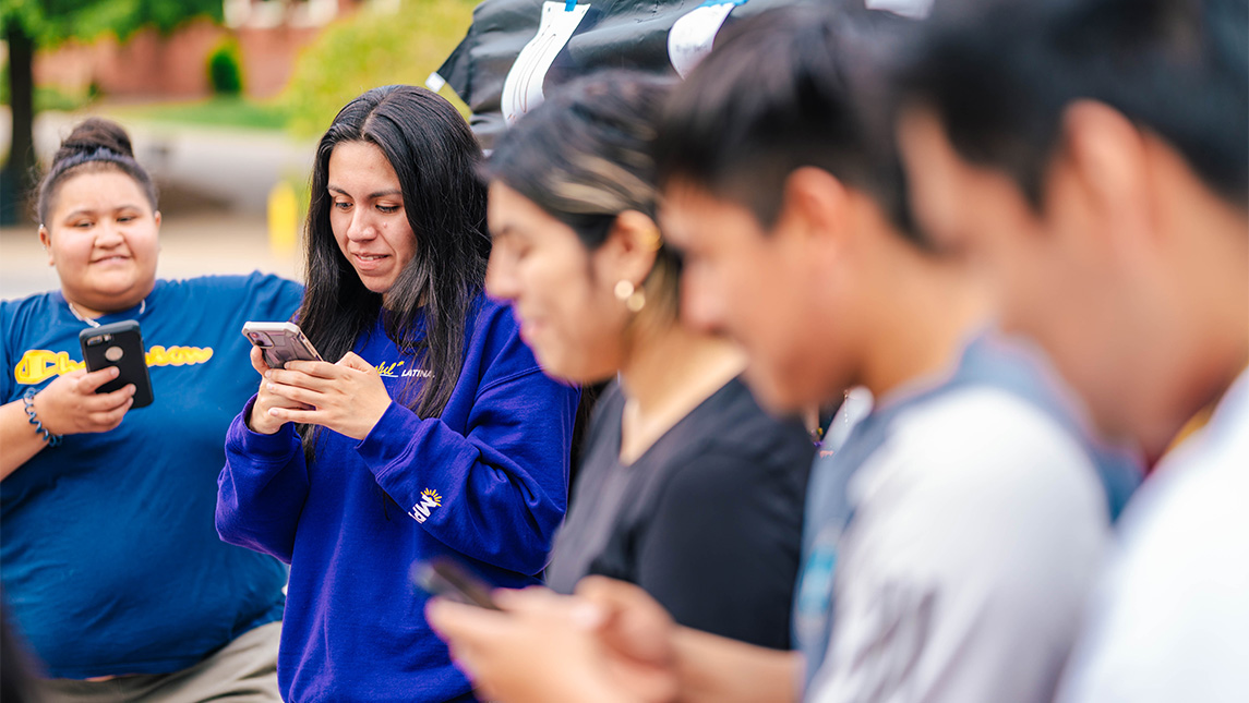 A group of college students using their phones.