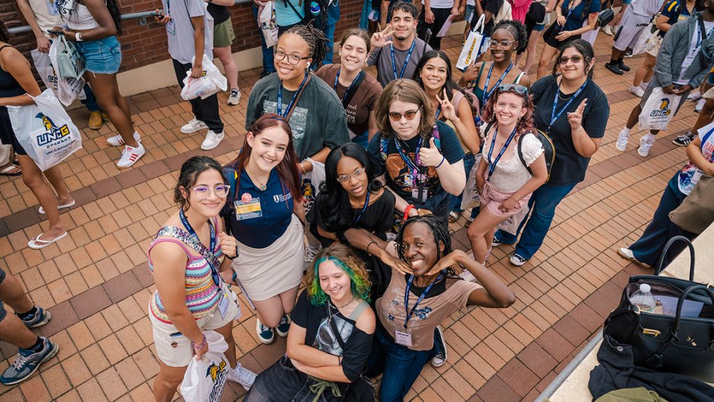 A cluster of students pose for a photo from above.