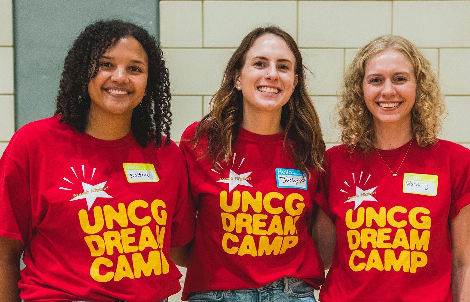 Three female counselors wearing Dream Camp shirts.