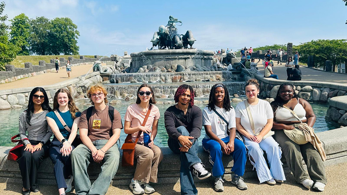 Honors students pose with a statue in Copenhagen, Denmark
