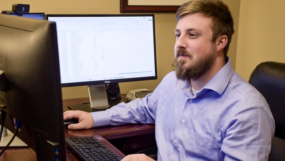 UNCG BSBE alumnus Noah Brabble working at a computer.