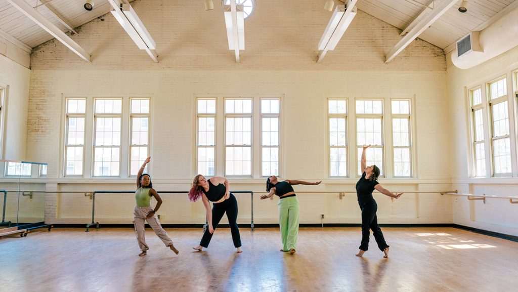 Four dancers practice in a studio.