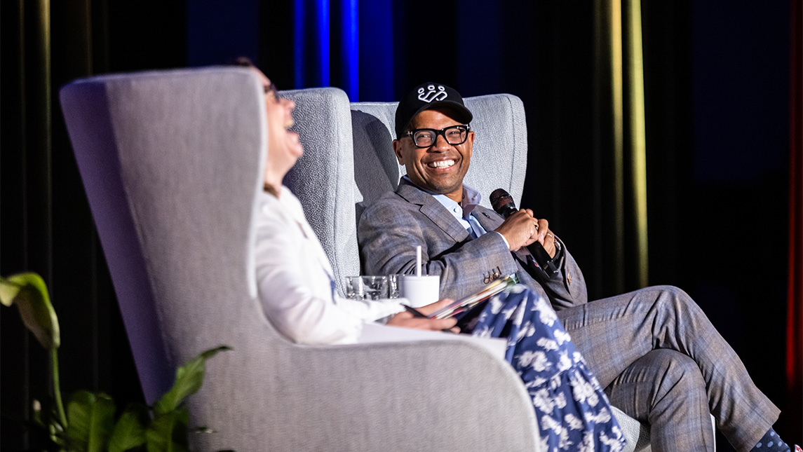 Demond Martin sits in a chair on a stage.