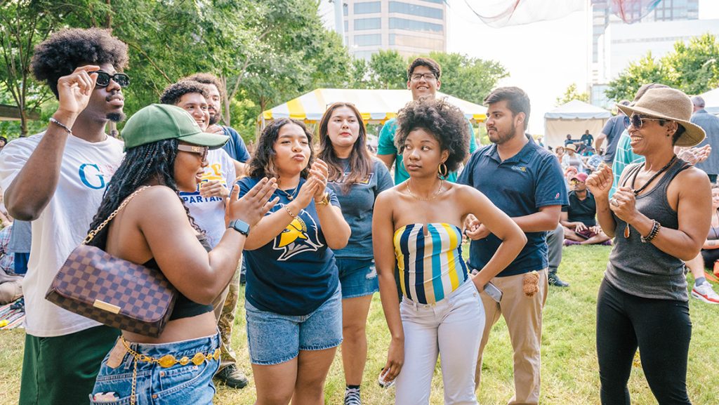Group of students dancing in the park at Folk Fest.