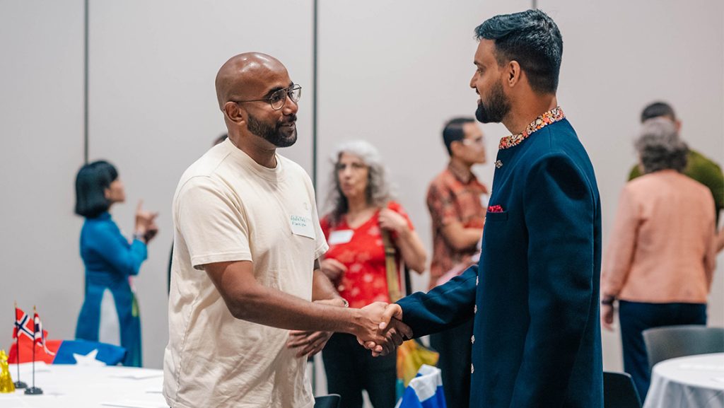 Two men shake hands.