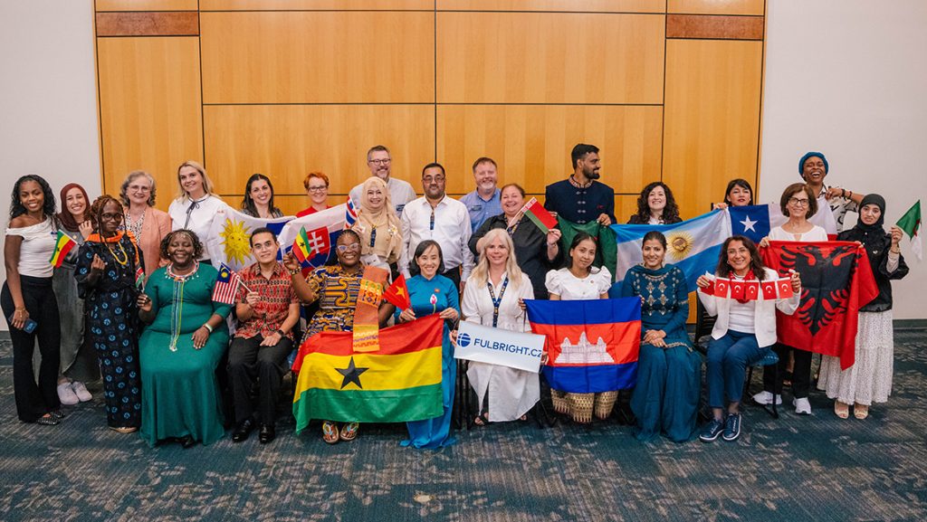 A group photo of people holding flags and wearing national folk dress.