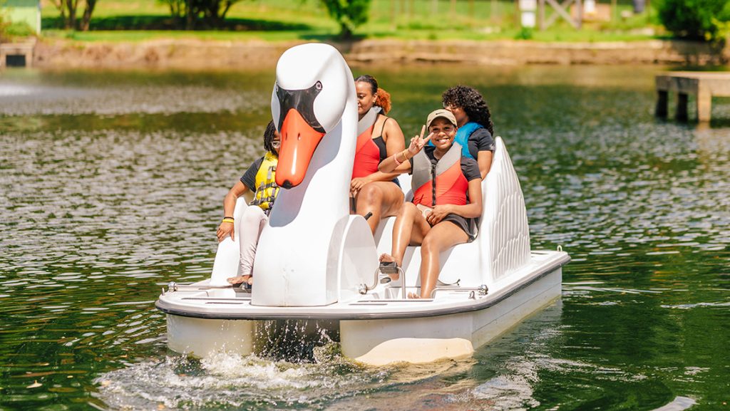 A group of UNCG students riding a swan paddleboat.