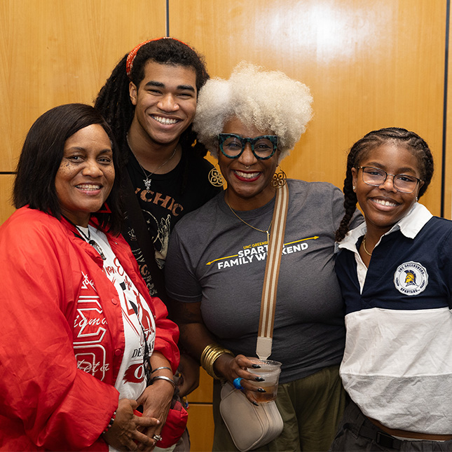 Student poses with his mom, grandma and sister.