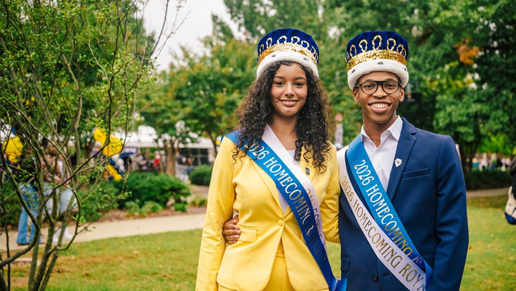 Homecoming king and queen pose on UNCG's campus.