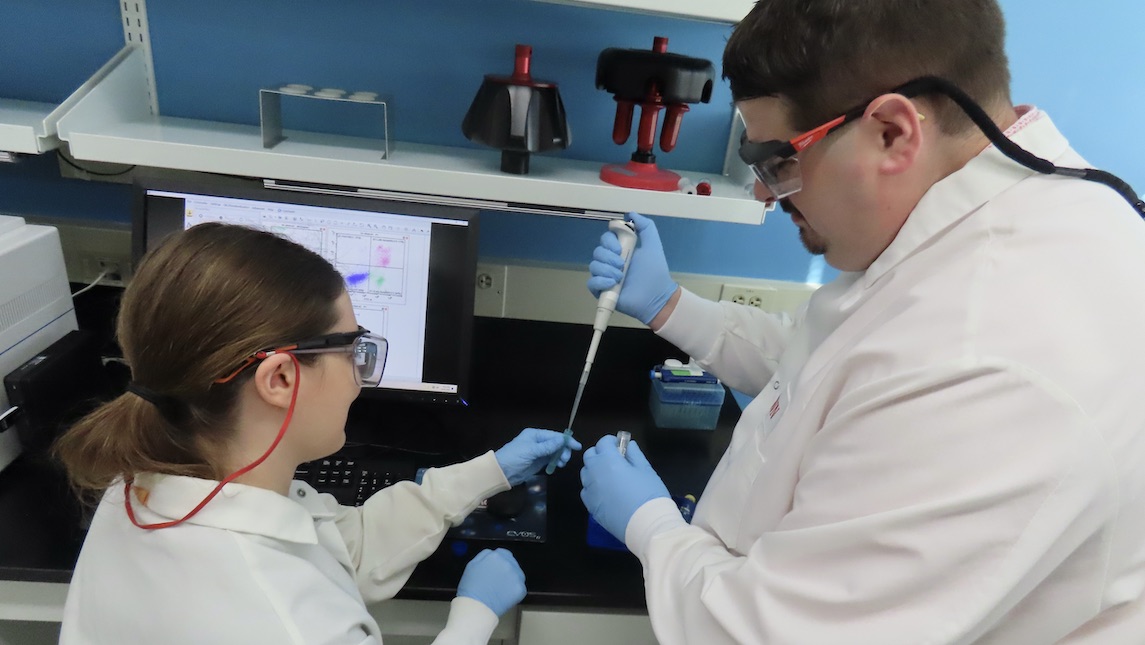 JSNN JSIRT's Dr. Luke Dixon working in the lab with an assistant.