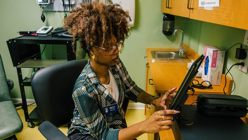 A woman types at an office computer.