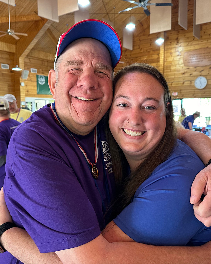 Two people hug inside a cabin.