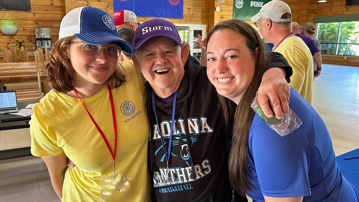 Kristin Bogner with arms around a camp participant and a volunteer.