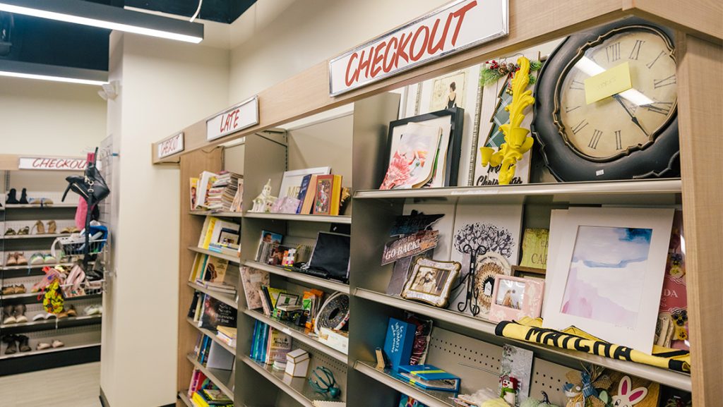 A shelf full of clocks, frames, books, and decor.