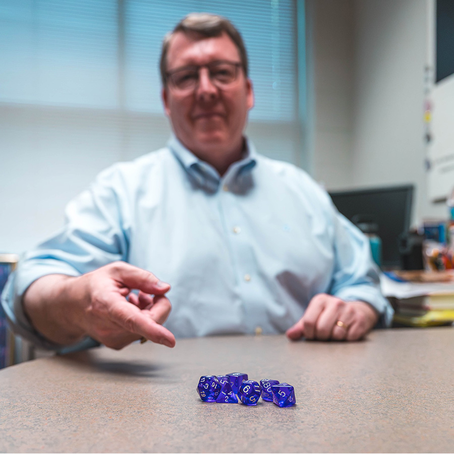 Dr. Rick Barton rolls Dungeons and Dragons dice.