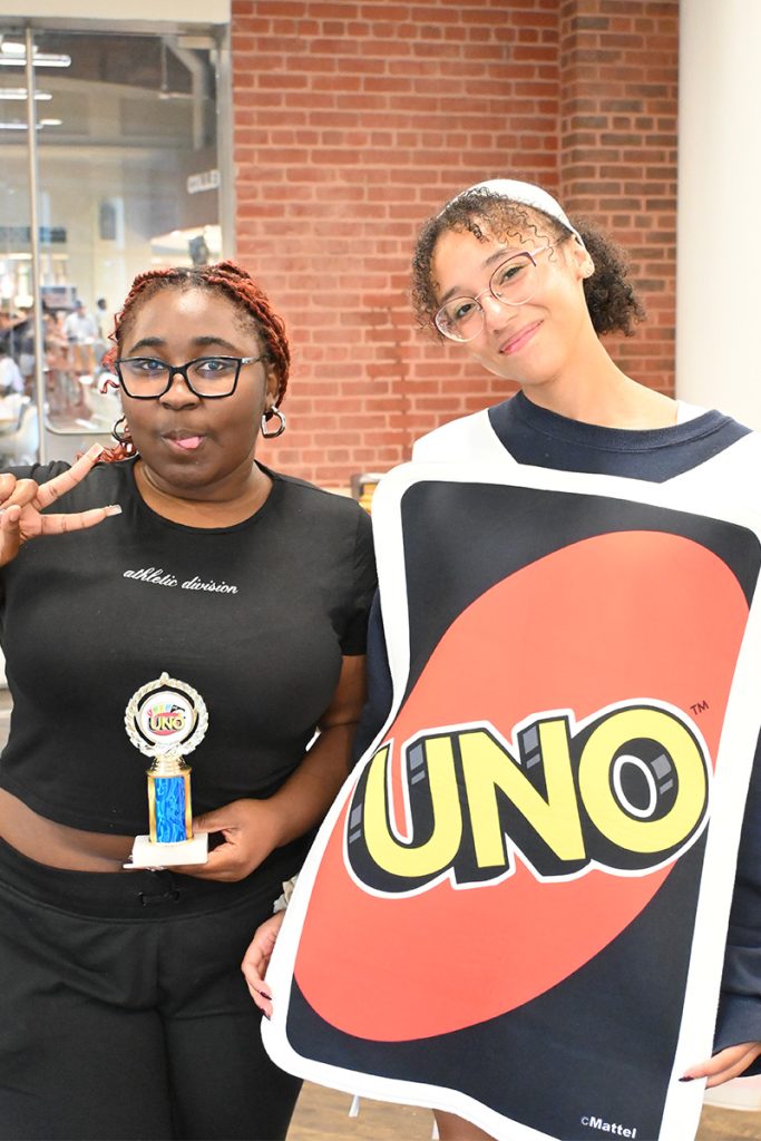A woman wearing a giant UNO costume.