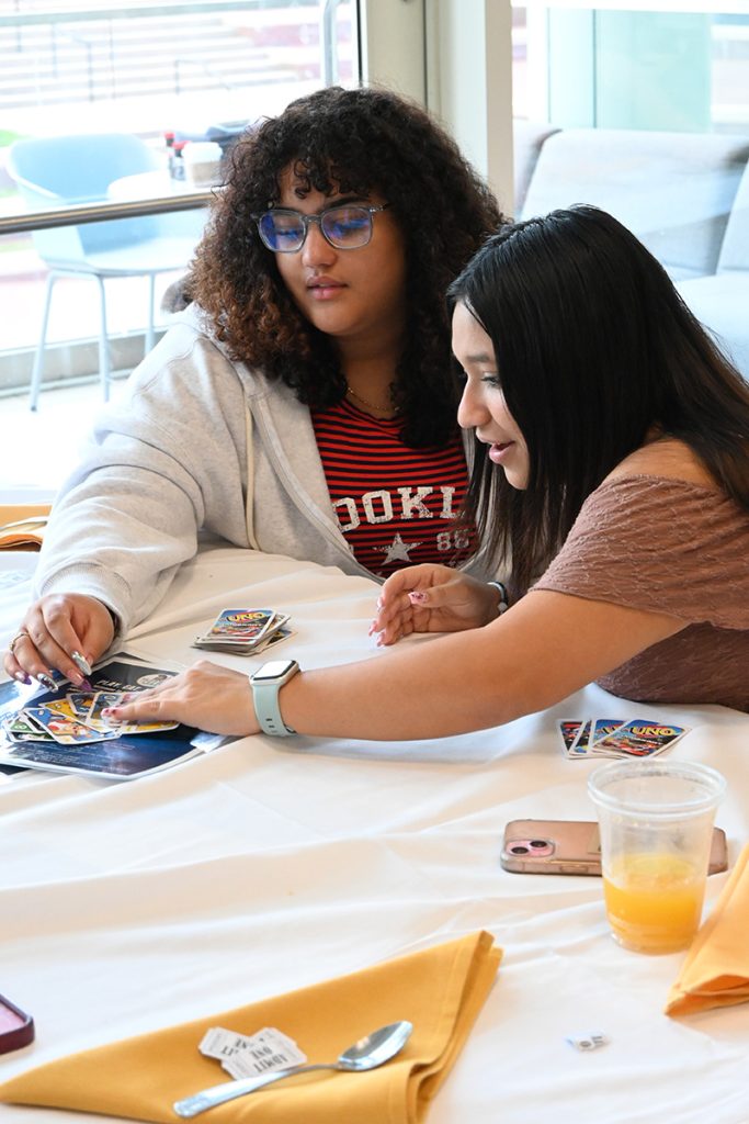 Women pull from an UNO card deck.